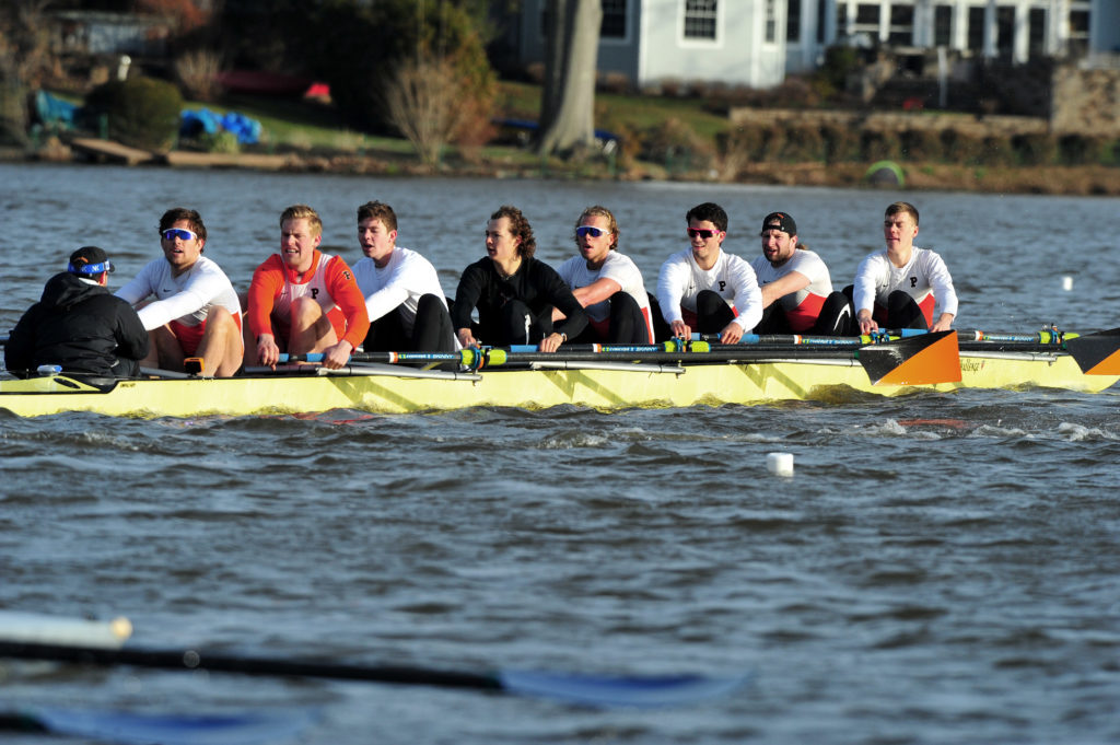 A group of people rowing a boat in the water