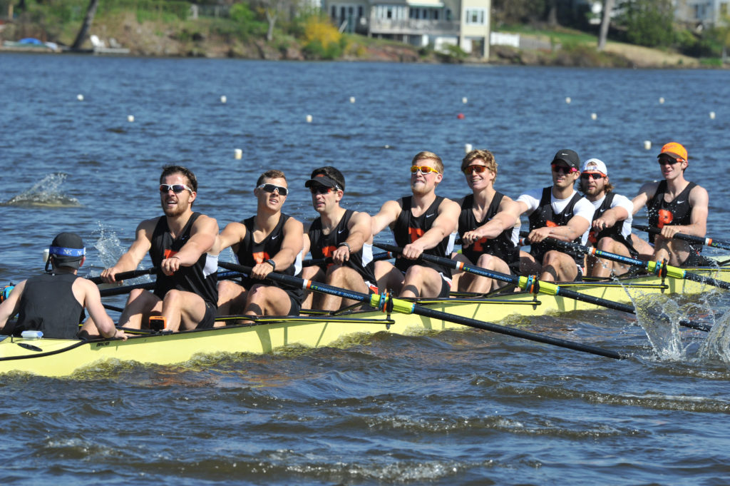 A group of people rowing a boat in a body of water