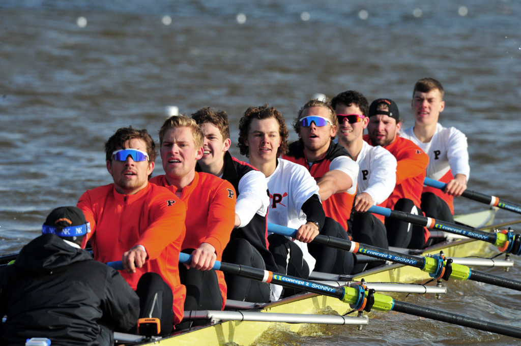 A group of people rowing a boat in the water