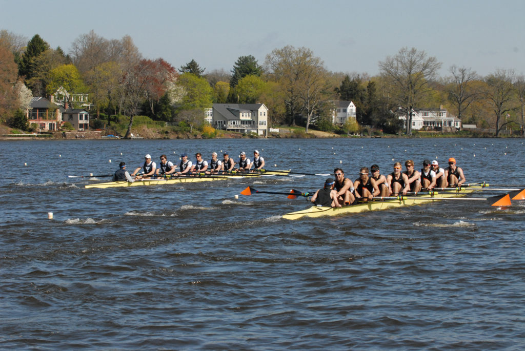 A group of people rowing a boat in a body of water