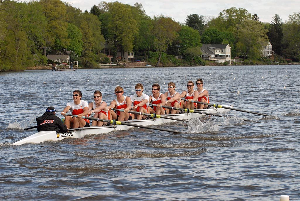 A group of people rowing a boat in a body of water