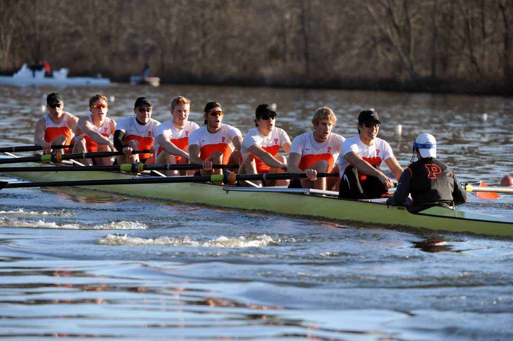 A group of people rowing a boat in the water