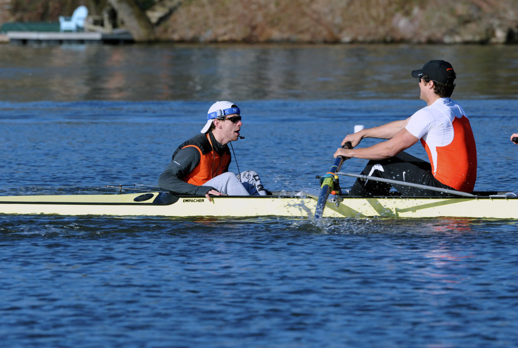 A group of people rowing a boat in a body of water