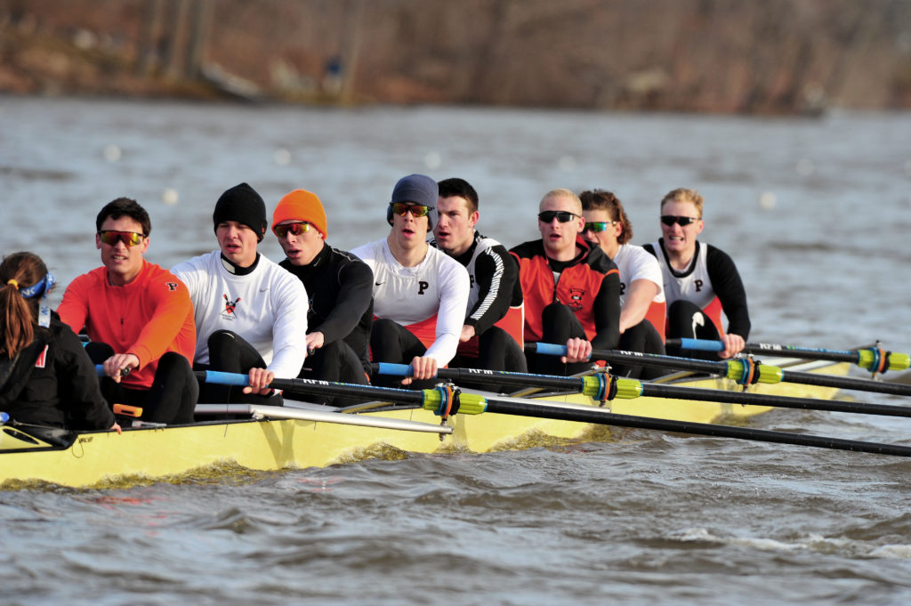 A group of people rowing a boat in the water