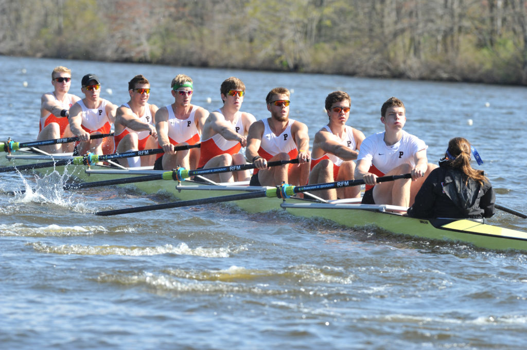 A group of people rowing a boat in a body of water