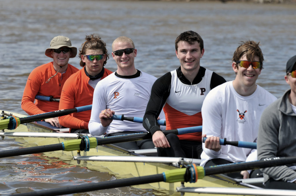 A group of people rowing a boat in the water