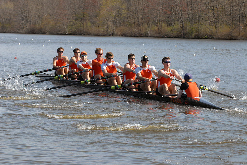 A group of people rowing a boat in the water