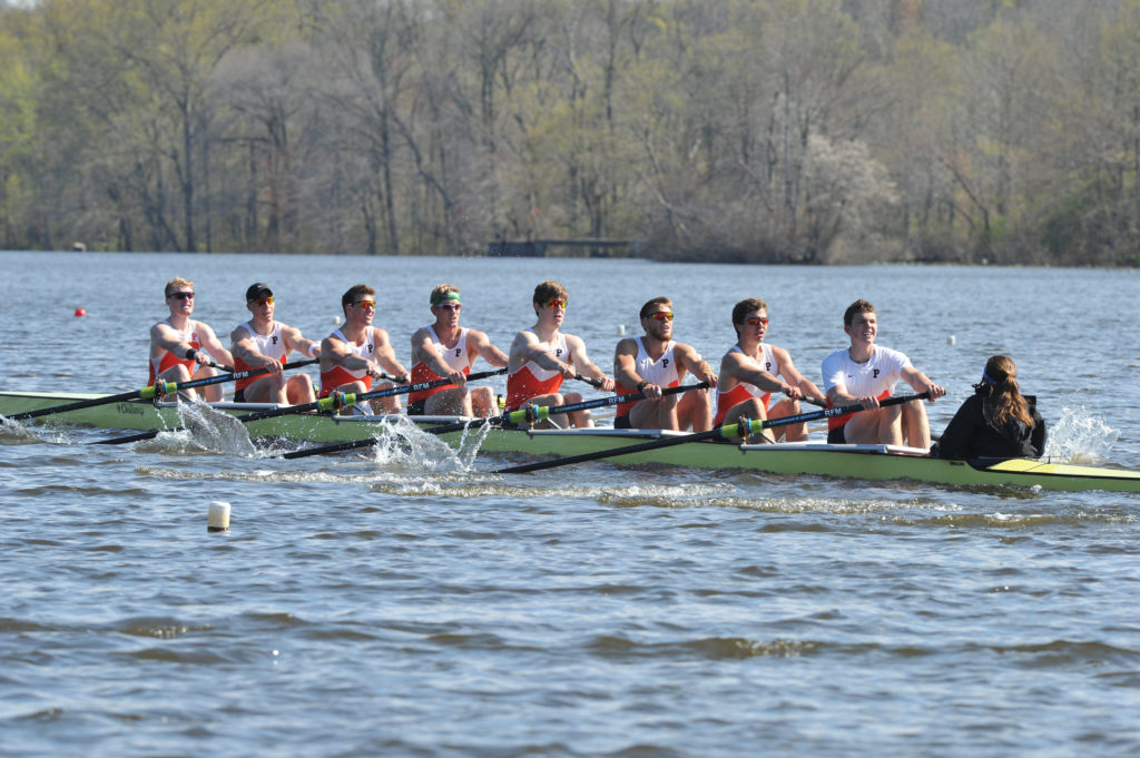 A group of people rowing a boat in a body of water