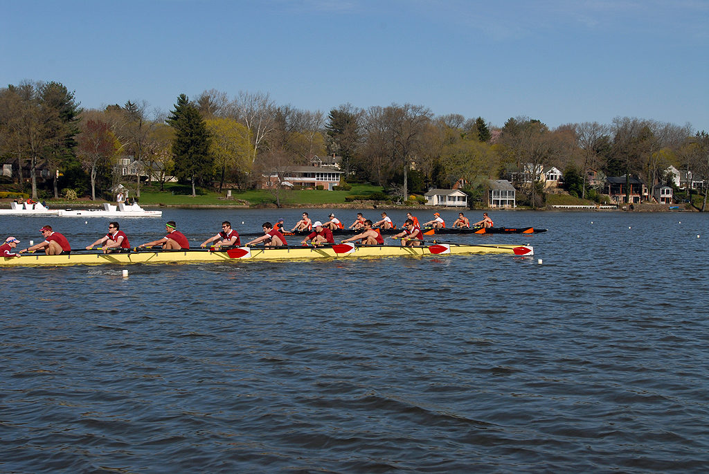 A group of people rowing a boat in a large body of water