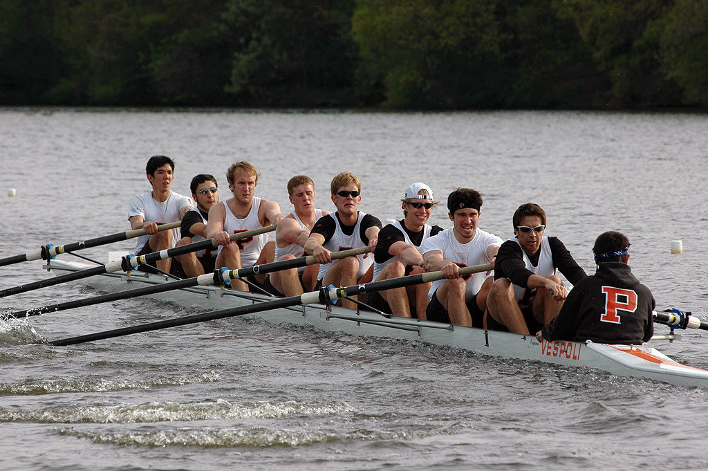 A group of people rowing a boat in a body of water