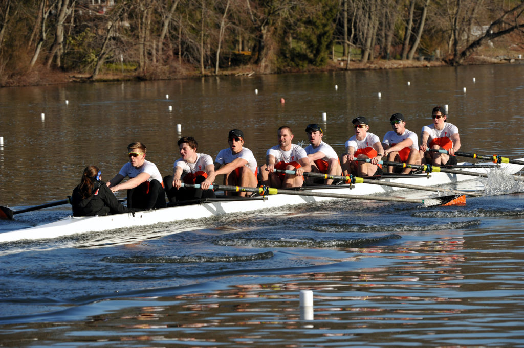 A group of people rowing a boat in the water