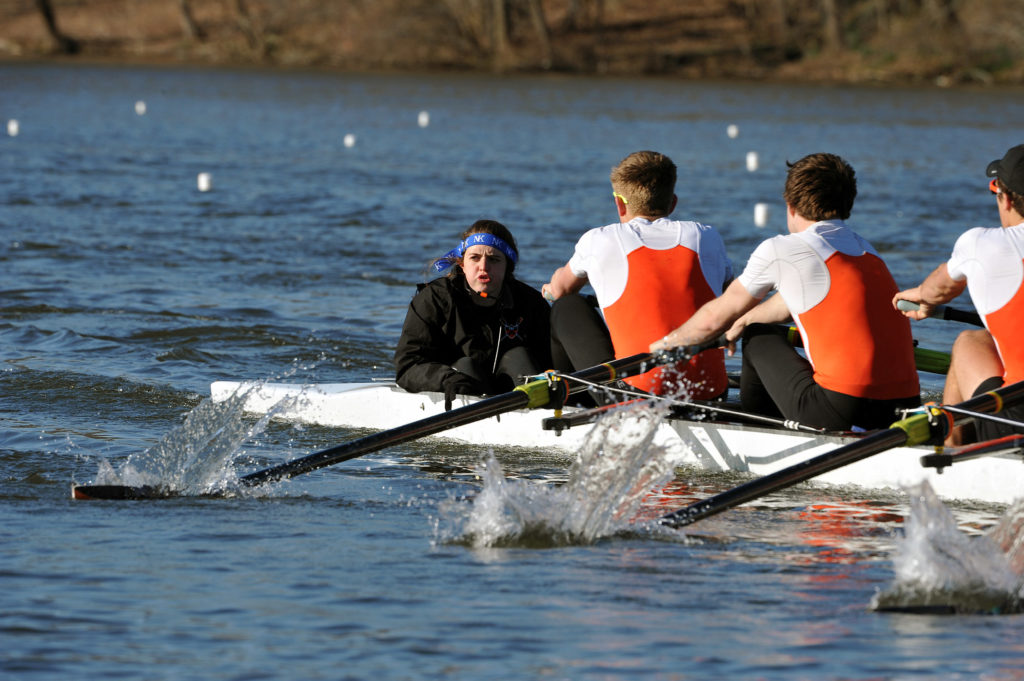 A group of people rowing a boat in a body of water