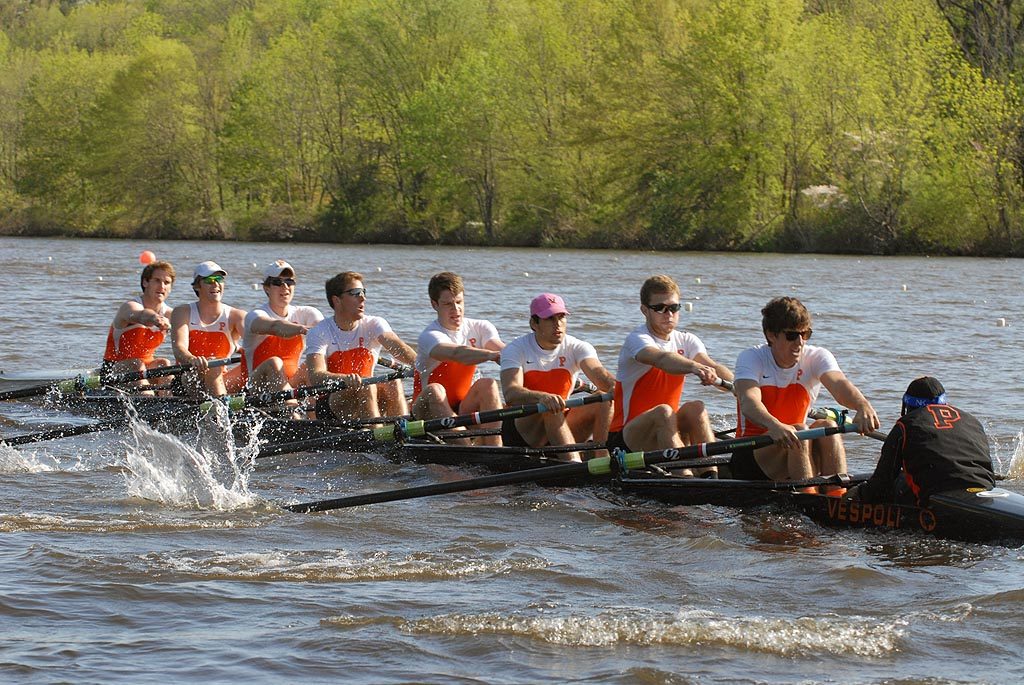 A group of people rowing a boat in a body of water