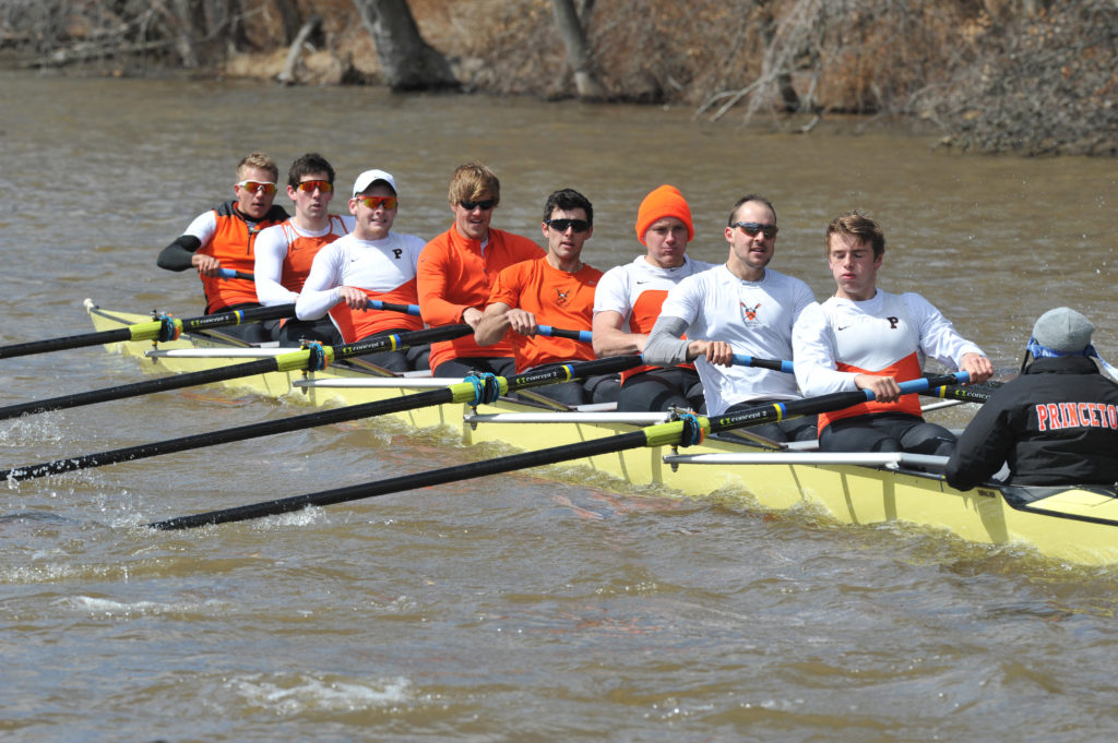 A group of people rowing a boat in the water