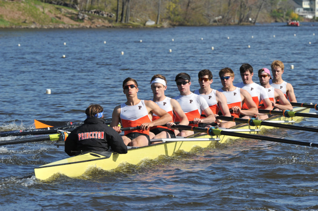 A group of people rowing a boat in a body of water