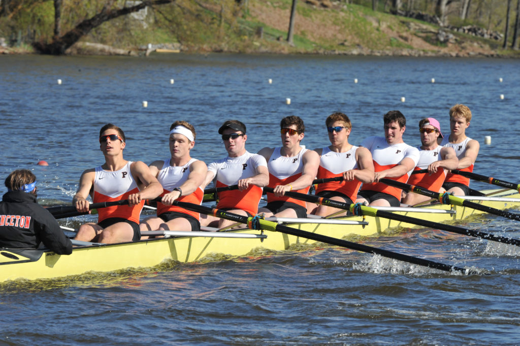 A group of people rowing a boat in a body of water