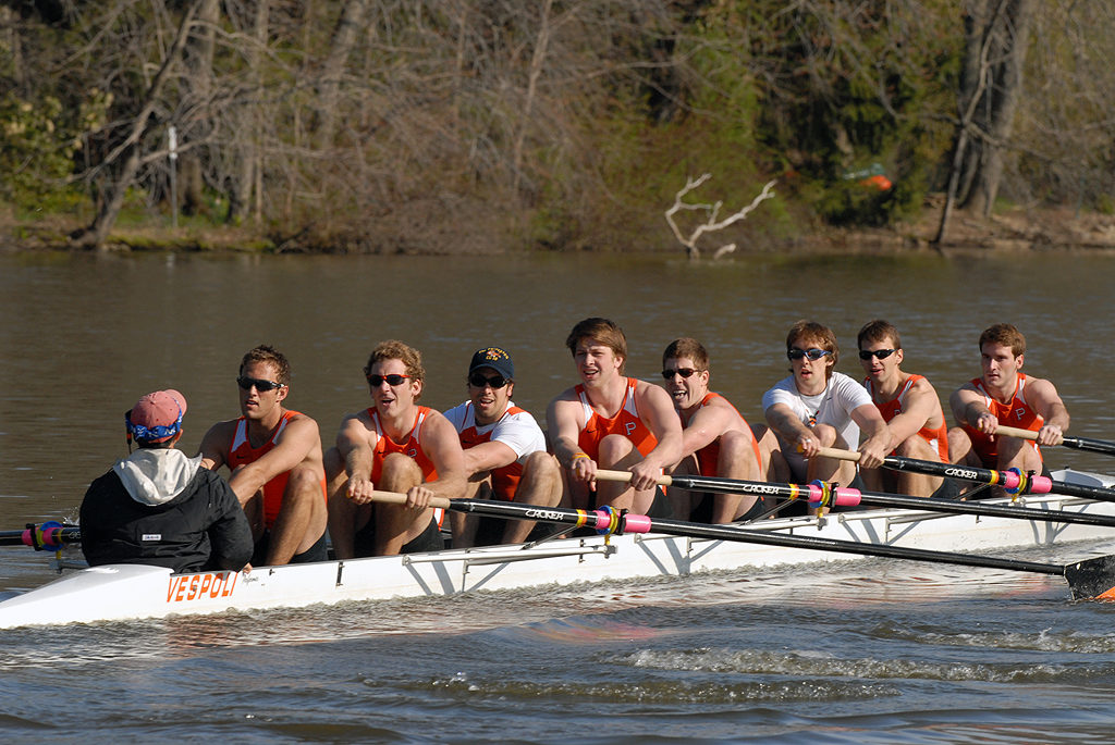 A group of people rowing a boat in the water