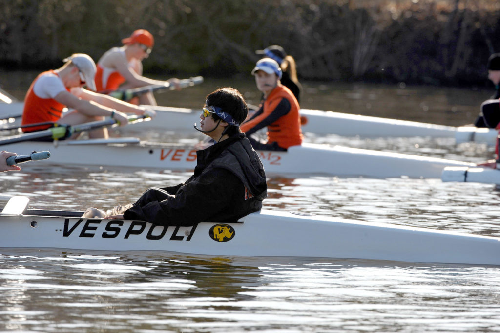 A group of people rowing a boat in the water