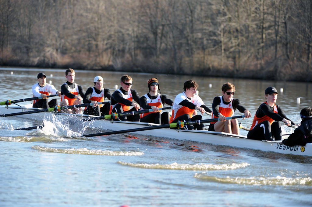 A group of people rowing a boat in the water