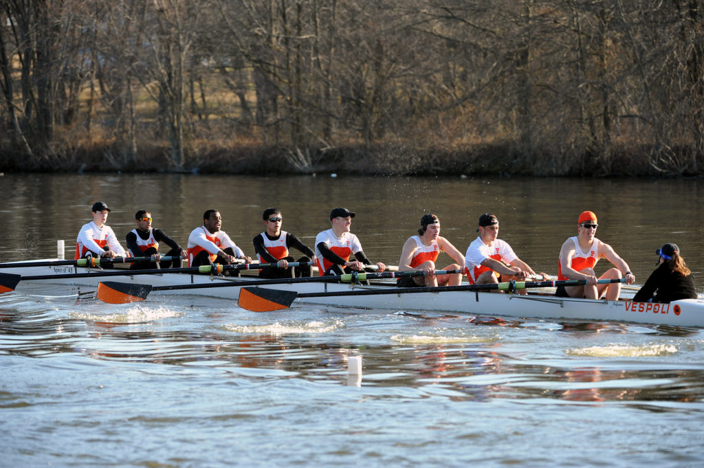 A group of people rowing a boat in the water