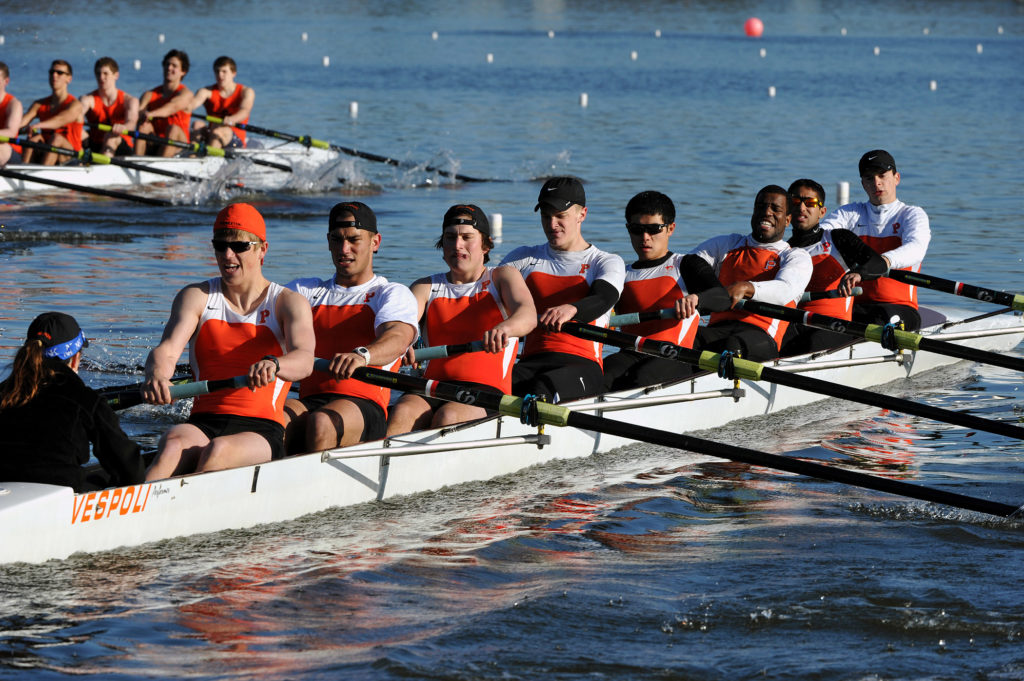 A group of people rowing a boat in the water