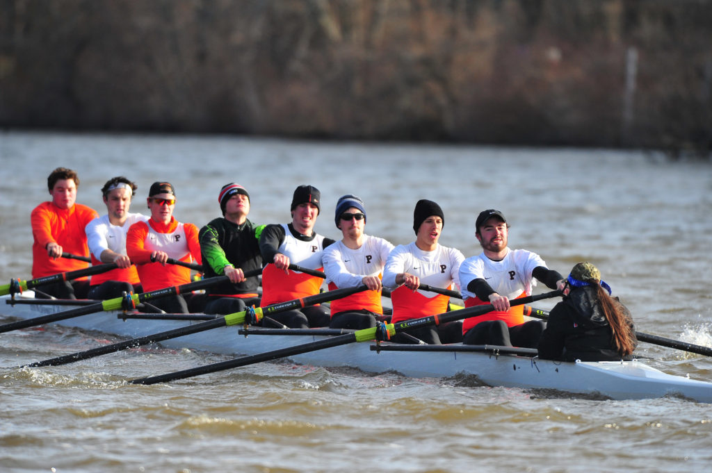 A group of people rowing a boat in the water