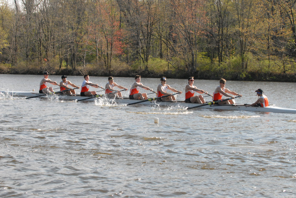 A group of people rowing a boat in the water