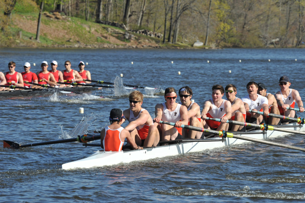 A group of people rowing a boat in the water