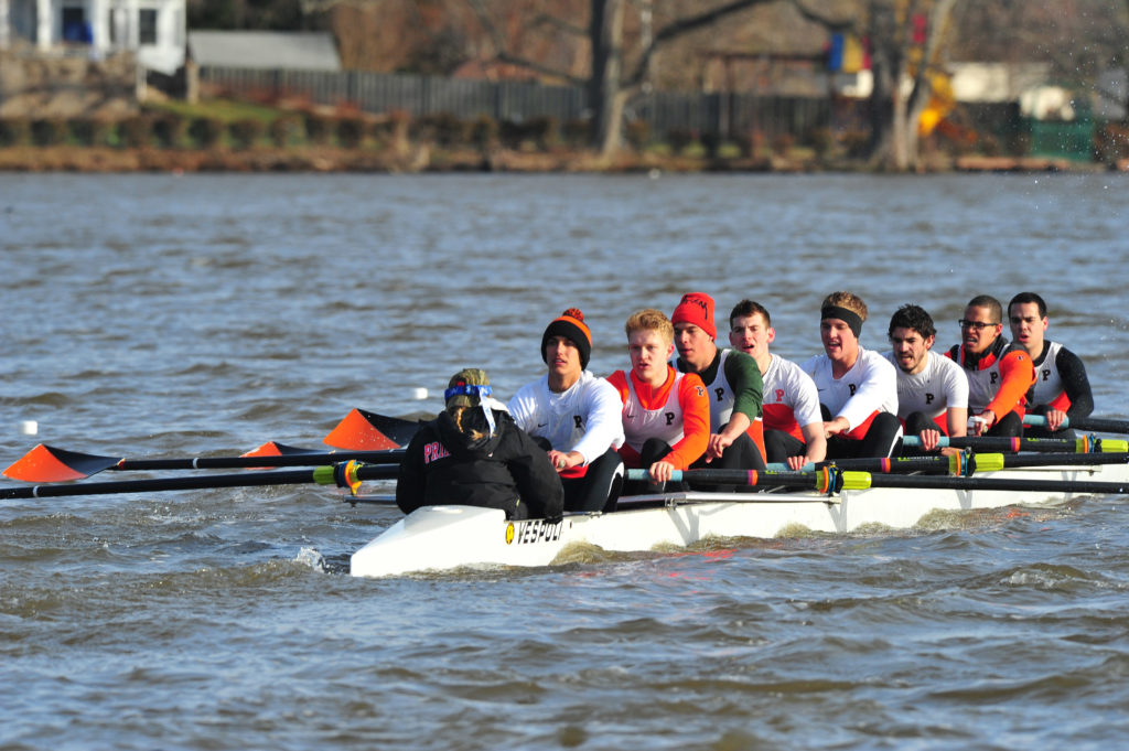 A group of people rowing a boat in a body of water