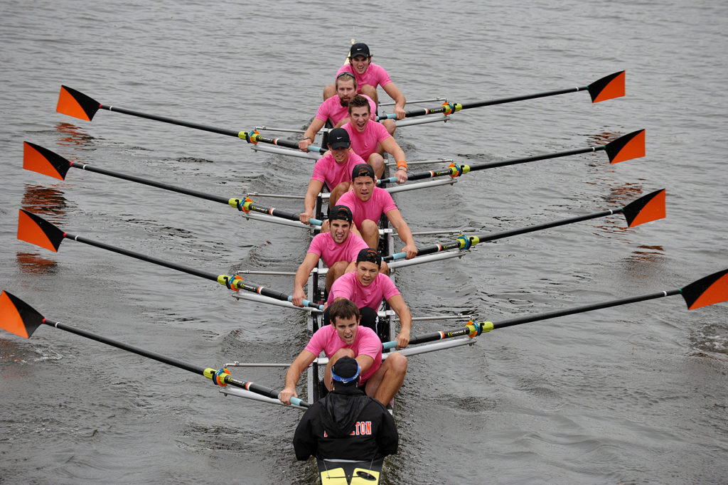 A group of people rowing a boat in the water