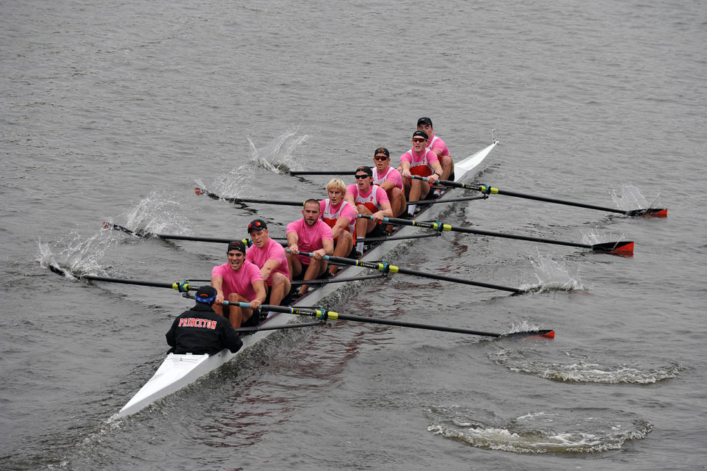 A group of people rowing a boat in the water