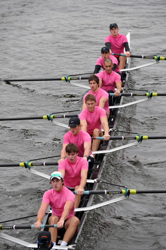 A group of people rowing a boat in the water