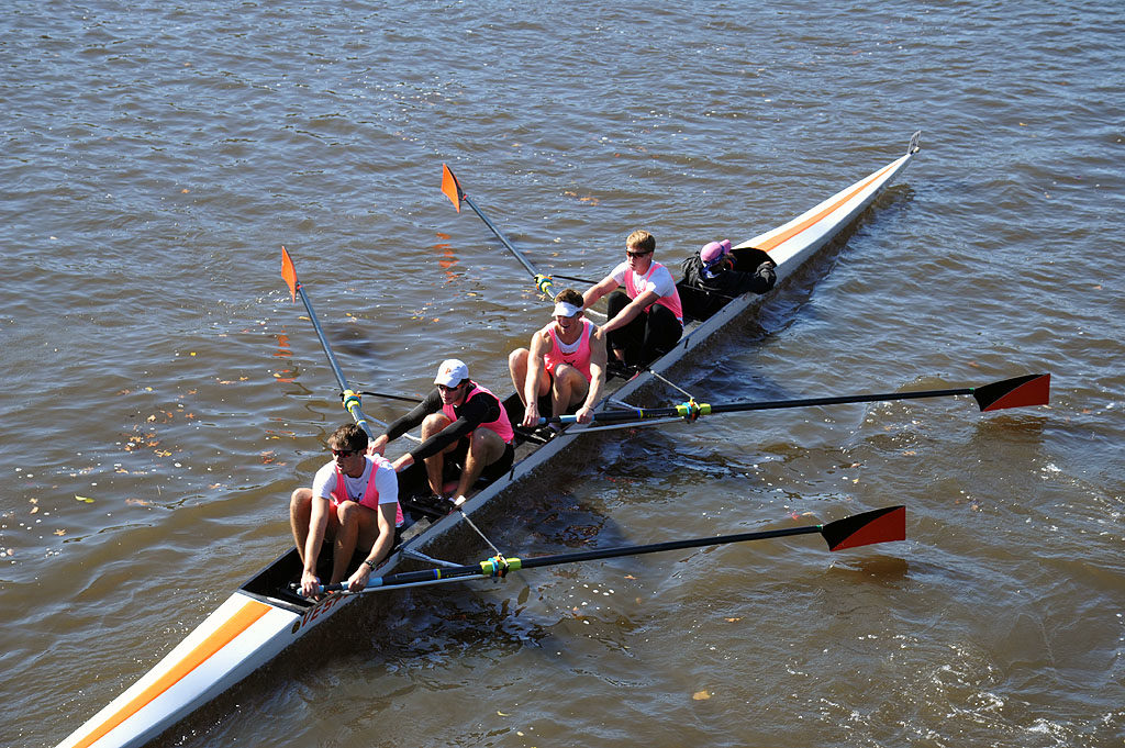 A group of people rowing a boat in a body of water