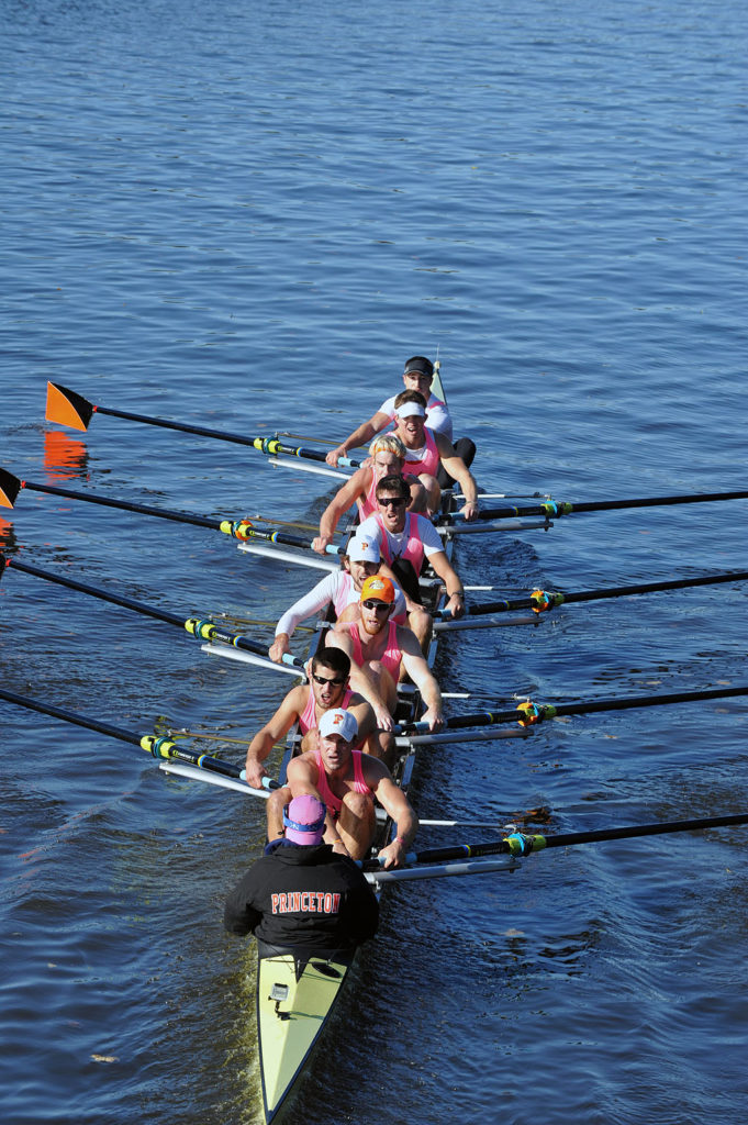 A group of people rowing a boat in a body of water