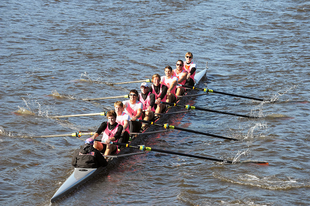 A group of people rowing a boat in the water