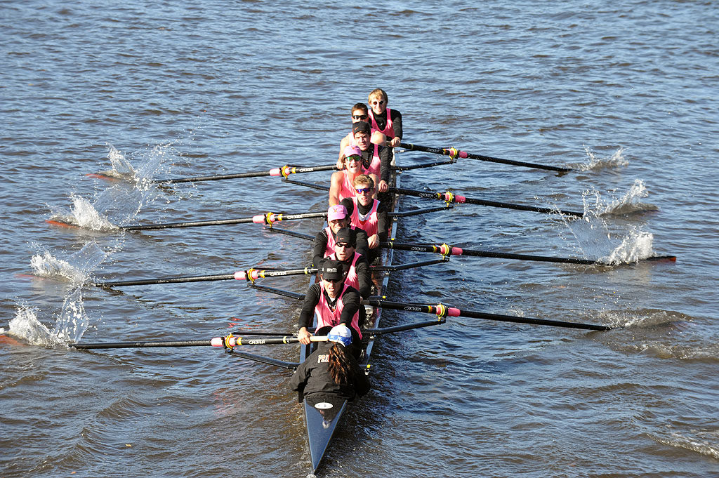 A group of people rowing a boat in the water