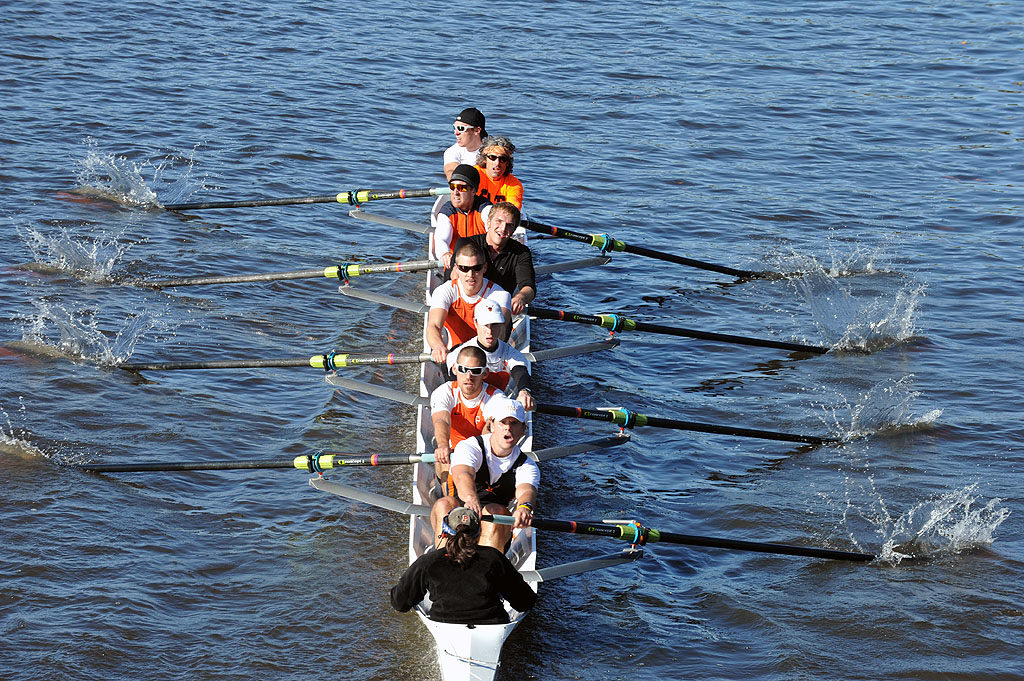 A group of people rowing a boat in a body of water