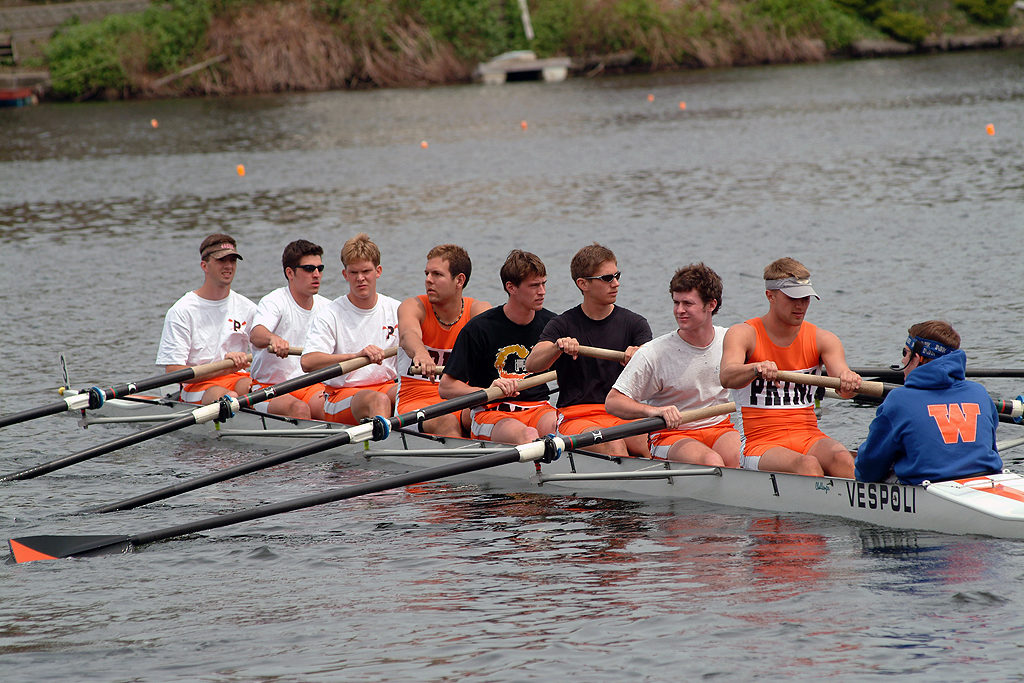 A group of people rowing a boat in the water