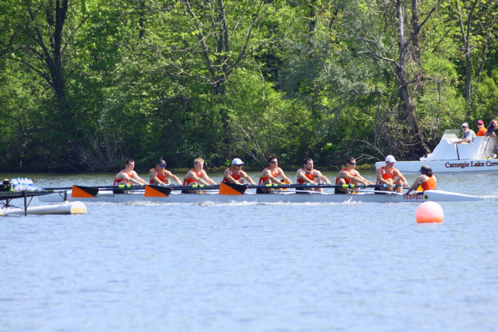 A group of people rowing a boat in the water