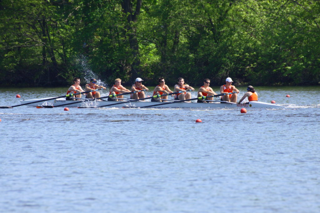 A group of people rowing a boat in a body of water