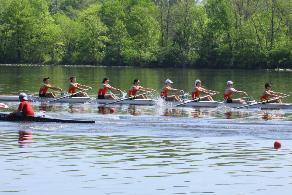 A group of people rowing a boat in the water