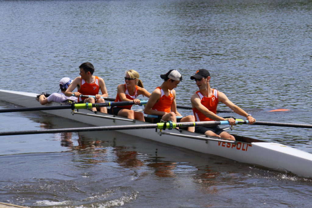 A group of people rowing a boat in the water