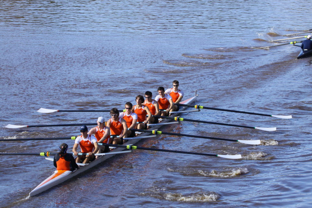 A group of people rowing a boat in the water