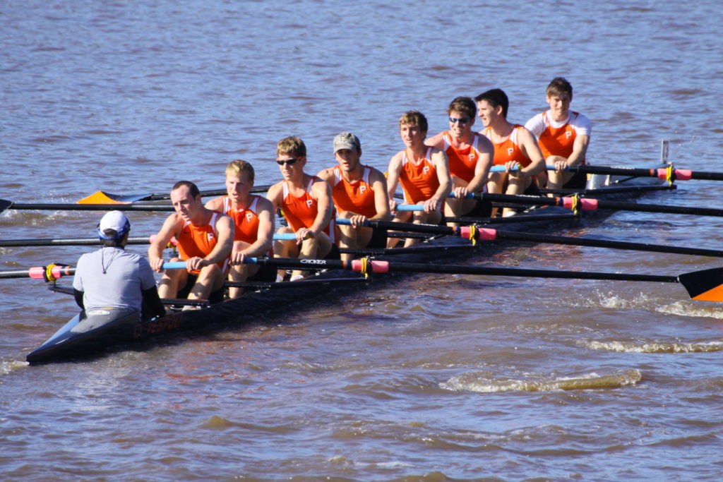 A group of people rowing a boat in the water