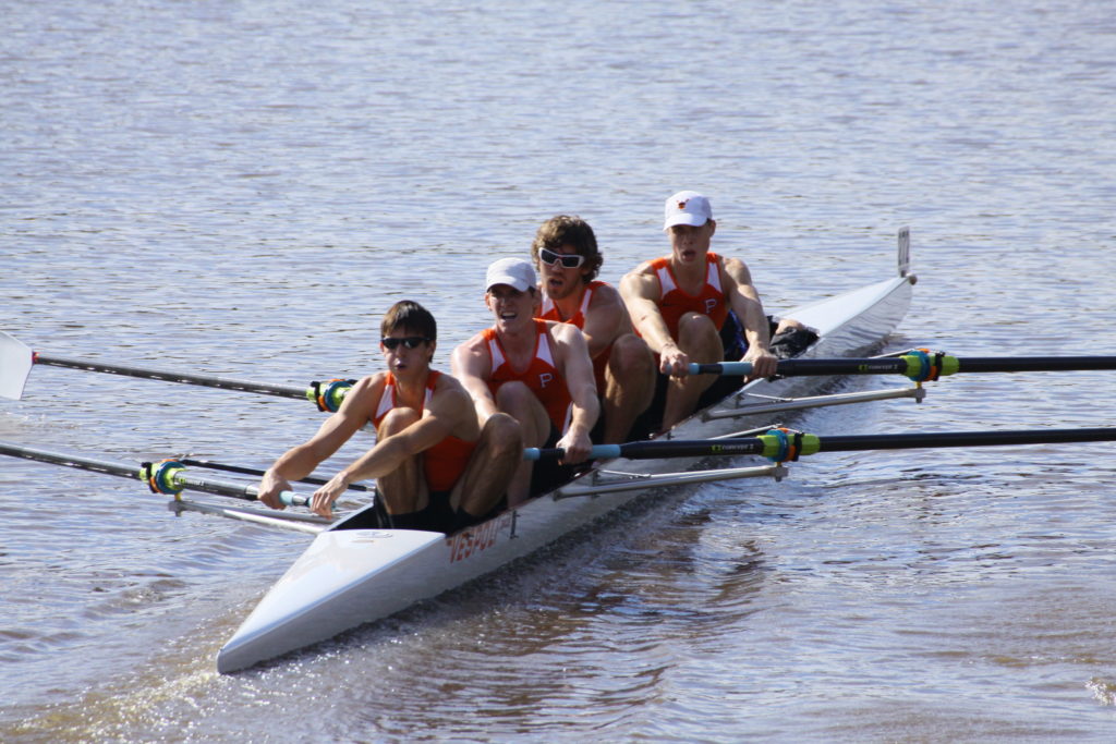 A group of people rowing a boat in the water