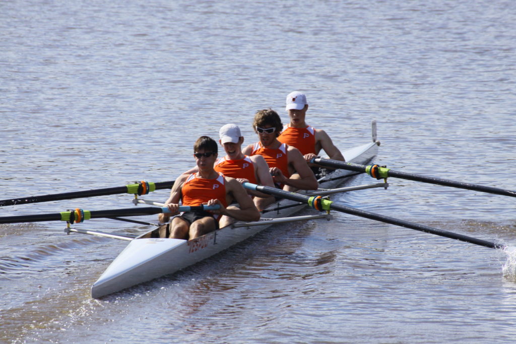 A group of people rowing a boat in the water