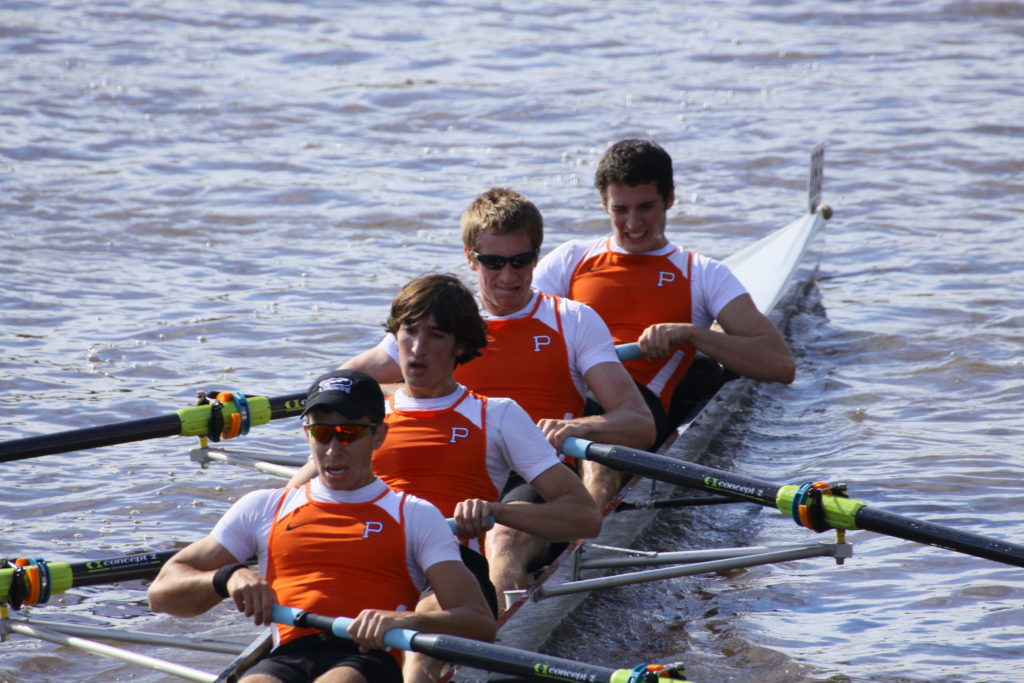 A group of people rowing a boat in the water