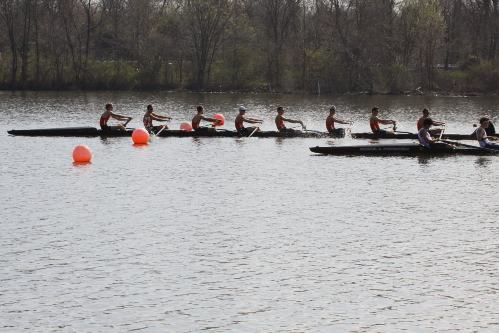 A group of people rowing a boat in a body of water