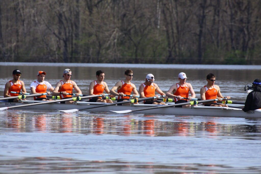 A group of people rowing a boat in the water