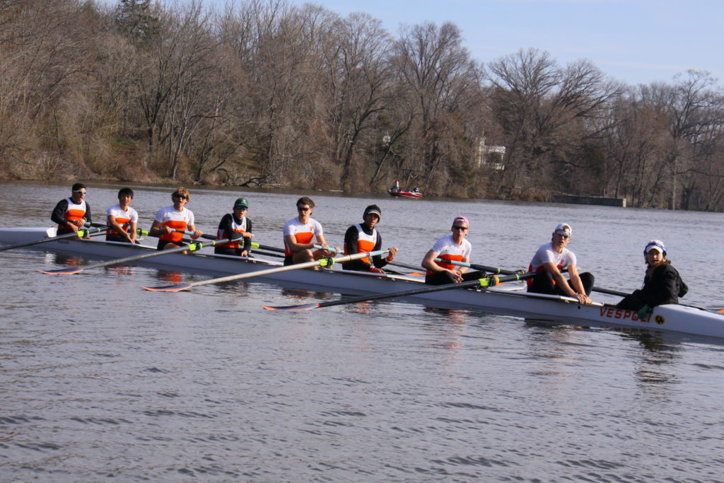 A group of people rowing a boat in the water